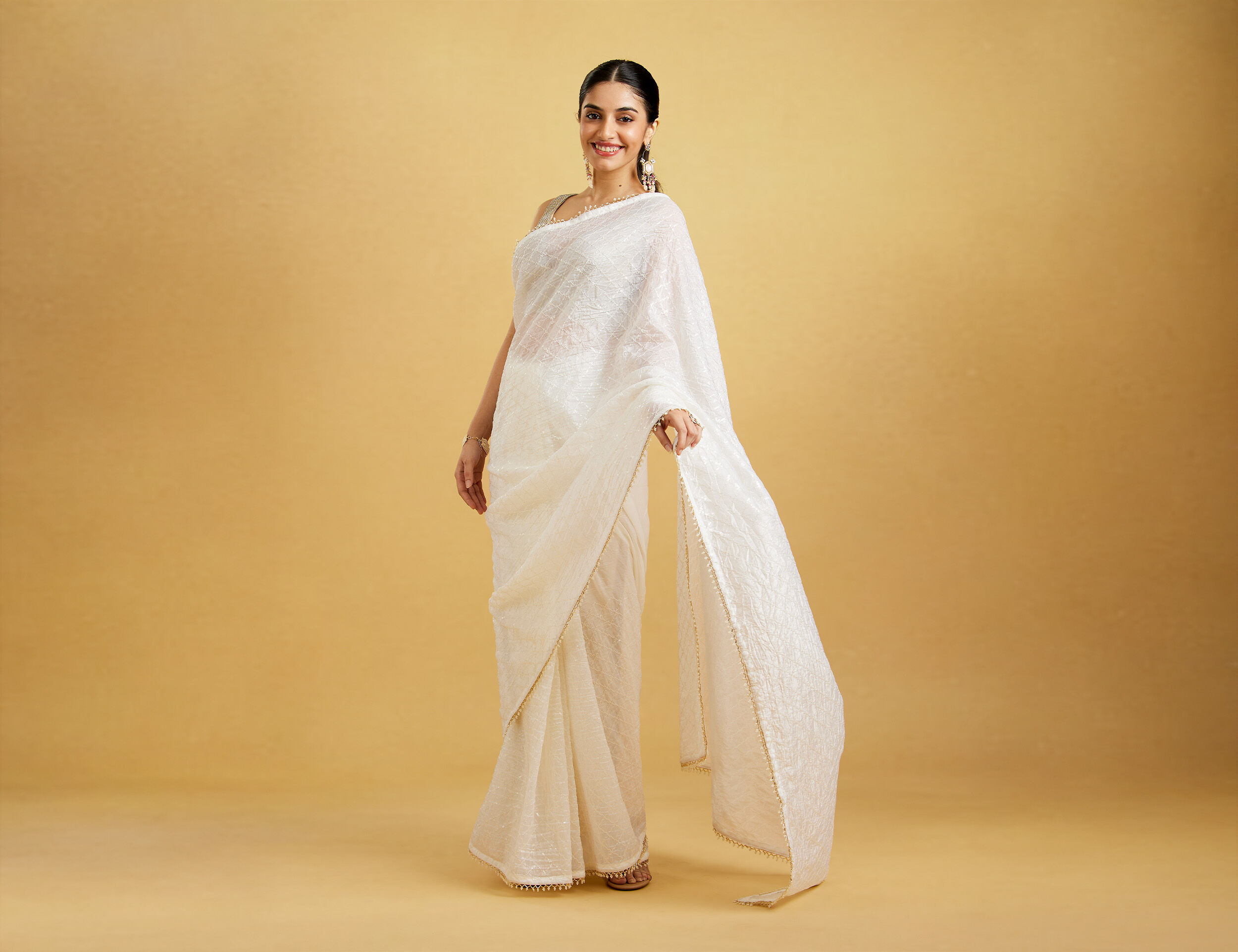 A lady posing in an embellished saree